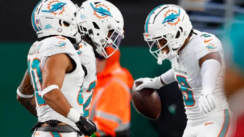 Miami Dolphins safety Jevon Holland (8) celebrates with teammates after running an interception back for a touchdown against the New York Jets during the second quarter of an NFL football game, Friday, Nov. 24, 2023, in East Rutherford, N.J. (AP Photo/Noah K. Murray)